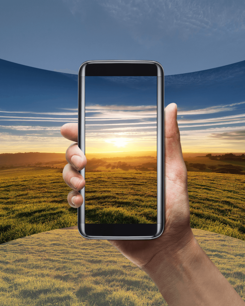 Una mano sostiene un teléfono celular con la pantalla encendida, mostrando un lugar turístico en realidad virtual (VR). En la pantalla se pueden ver imágenes inmersivas del destino turístico, ofreciendo una experiencia envolvente al usuario.